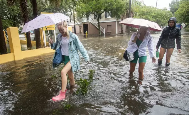 Pedestrians make their way down Montagu St. in Charleston, S.C., as Tropical Storm Debby approaches, Tuesday, Aug. 6, 2024. (AP Photo/Mic Smith)