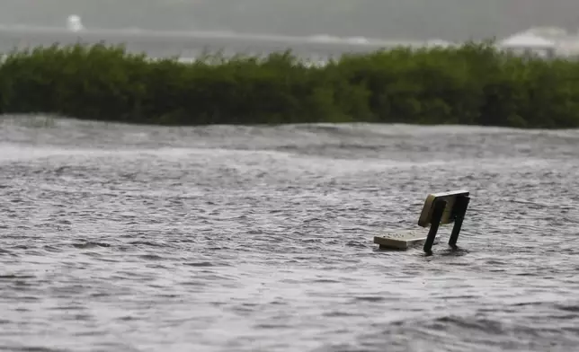 A bench is submerged in water near the R.E. Olds Park, Monday morning, Aug. 5, 2024, in Oldsmar Fla., as Hurricane Debby passes the Tampa Bay area offshore. (Jefferee Woo//Tampa Bay Times via AP)