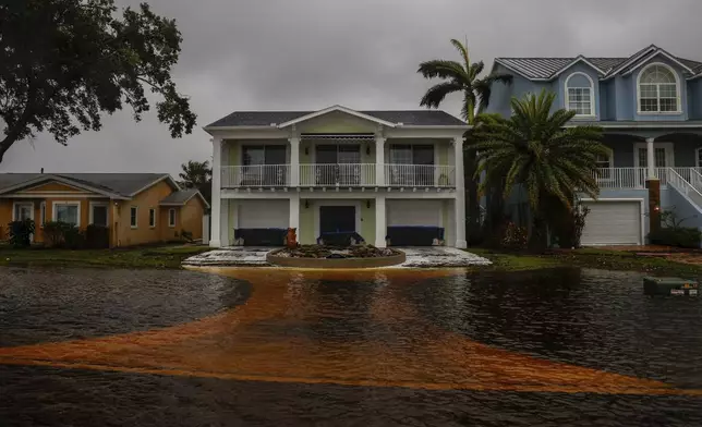 Water almost reaches houses along Shore Drive East near R.E. Olds Park, Monday morning, Aug. 5, 2024, in Oldsmar Fla., as Hurricane Debby passes the Tampa Bay area offshore. (Jefferee Woo//Tampa Bay Times via AP)