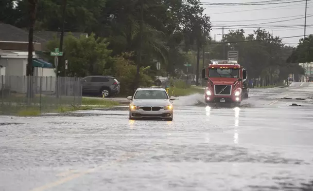 A vehicle is disabled in the flood water along S. 22nd street, Monday morning, Aug. 5, 2024 in Tampa, Fla., as Hurricane Debby passes the Tampa Bay area offshore. ( (Luis Santana//Tampa Bay Times via AP)