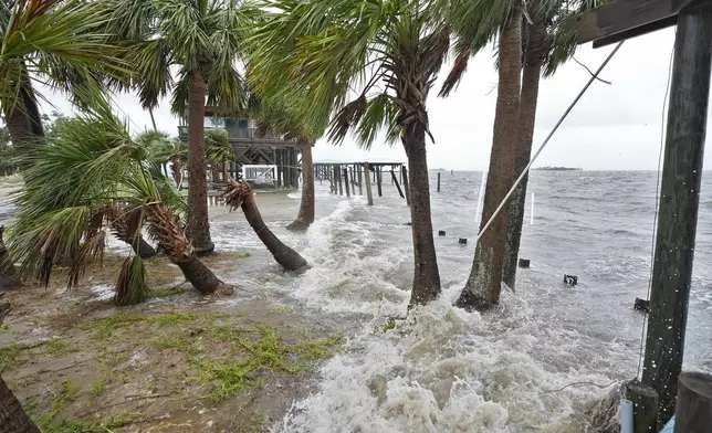 Storm surge pushes water past wind swept palm trees along the Gulf of Mexico, Monday, Aug. 5, 2024, in Horseshoe Beach, Fla. Hurricane Debby made landfall early this morning.(AP Photo/Christopher O'Meara)