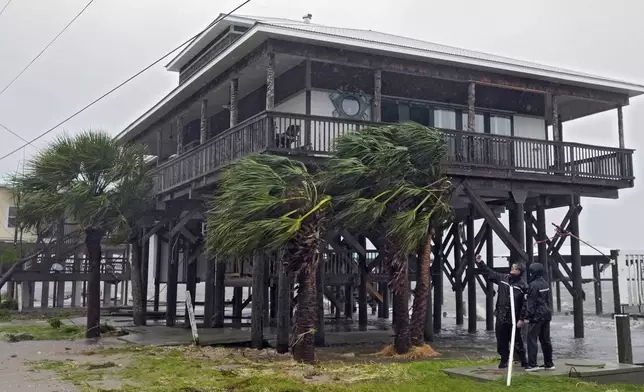 Storm chasers check the wind speed near a home on the Gulf of Mexico Monday, Aug. 5, 2024, in Horseshoe Beach, Fla. Hurricane Debby made landfall early this morning. (AP Photo/Christopher O'Meara)