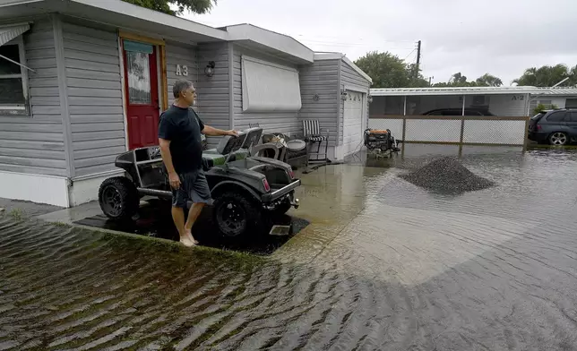 Roger Huffman's home in Bradenton's Villa Del Sol mobile home park is without power and surrounded by floodwater, Monday, Aug. 5, 2024, after Tropical Weather Debby swept through the area. (Tiffany Tompkins/The Bradenton Herald via AP)