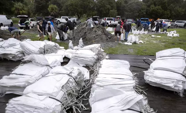 Residents prepare for Hurricane Debby by filling up sandbags provided by the county, Monday, Aug. 5, 2024, in Savannah, Ga. Forecasters warned heavy rain could spawn catastrophic flooding in Florida, Georgia and South Carolina. (AP Photo/Stephen B. Morton)