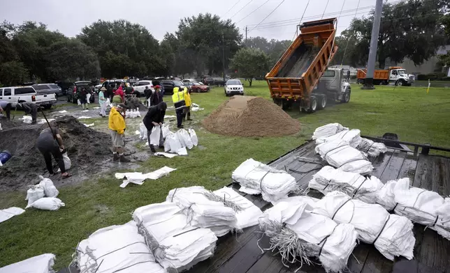 Chatham County employees dump a truck load of sand for residents to use in sandbag as they prepare for Hurricane Debby, Monday, Aug. 5, 2024, in Savannah, Ga. Forecasters warned heavy rain could spawn catastrophic flooding in Florida, South Carolina and Georgia. (AP Photo/Stephen B. Morton)