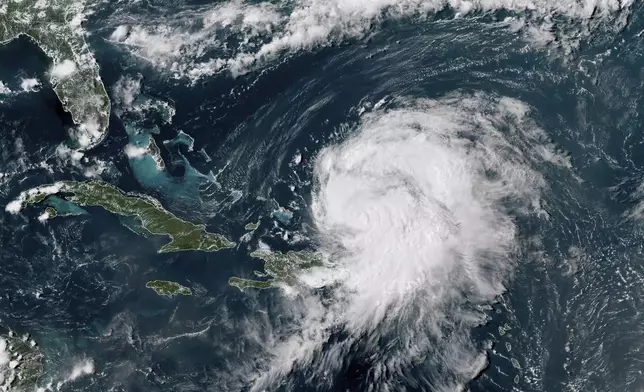 This GOES-16 GeoColor satellite image taken at 4 p.m EDT and provided by National Oceanic and Atmospheric Administration (NOAA) shows Hurricane Ernesto northwest of San Juan, Puerto Rico and moving over open waters, Wednesday, Aug. 14, 2024. (NOAA via AP)