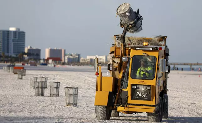 City workers empty trash cans to prepare for the storm at Clearwater Beach on Saturday, Aug. 3, 2024, in Clearwater, Fla. (Jefferee Woo/Tampa Bay Times via AP)