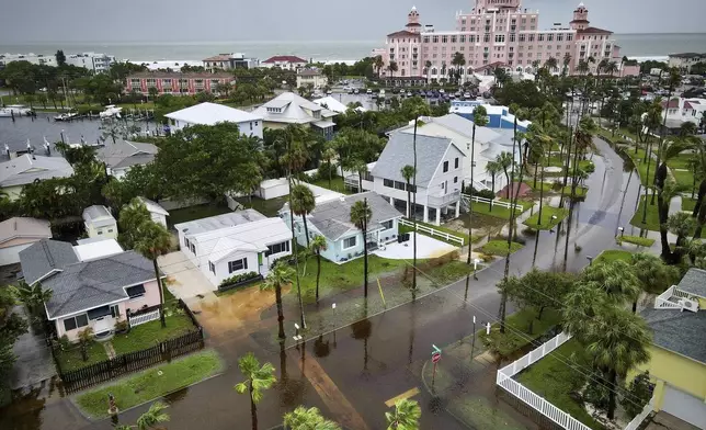 Flooding is seen near homes as The Don CeSar looms in the background Monday morning, Aug. 5, 2024 in St. Pete Beach, Fla., as Hurricane Debby passes the Tampa Bay area offshore. (Max Chesnes/Tampa Bay Times via AP)