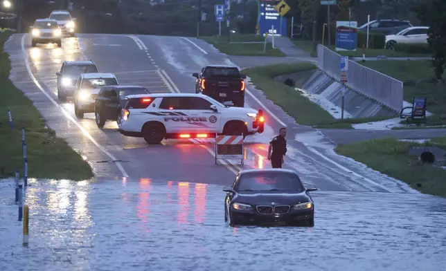 A BMW sedan is stalled in high water along southbound US Alt 19 in Tarpon Springs, Fla., Monday morning, Aug 5, 2024, as Hurricane Debby passes the Tampa Bay area offshore. (Douglas R. Clifford/Tampa Bay Times via AP)