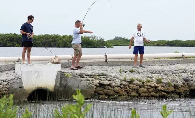 A trio of fishermen take advantage of the favorable weather conditions along Suncoast Key in Ozello, Fla., before Tropical Storm Debby makes landfall on Sunday, Aug. 4, 2024. (AP Photo/Christopher O'Meara)