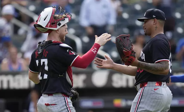 Minnesota Twins catcher Ryan Jeffers, left, and pitcher Jhoan Duran celebrate after a baseball game against the New York Mets at Citi Field, Wednesday, July 31, 2024, in New York. The Twins defeated the Mets 8-3. (AP Photo/Seth Wenig)