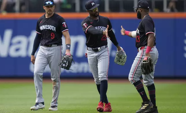 Minnesota Twins outfielders Trevor Larnach, left, Byron Buxton, center, and Manuel Margot celebrate after a baseball game against the New York Mets at Citi Field, Wednesday, July 31, 2024, in New York. The Twins defeated the Mets 8-3. (AP Photo/Seth Wenig)