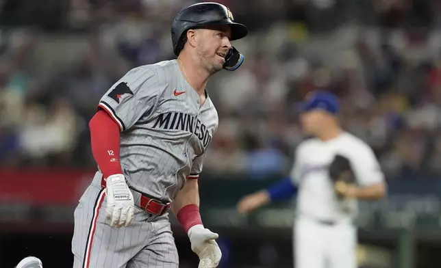 Minnesota Twins' Kyle Farmer sprints around third after hitting for a triple then scoring on a fielding error by Texas Rangers' Leody Taveras in the second inning of a baseball game, Thursday, Aug. 15, 2024, in Arlington, Texas. (AP Photo/Tony Gutierrez)