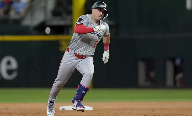 Minnesota Twins' Kyle Farmer sprints around second after hitting for a triple before scoring on a fielding error by Texas Rangers' Leody Taveras in the second inning of a baseball game, Thursday, Aug. 15, 2024, in Arlington, Texas. (AP Photo/Tony Gutierrez)