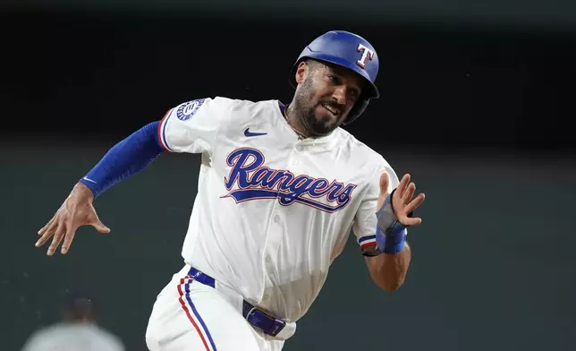 Texas Rangers' Marcus Semien rounds third on his way home, scoring on Adolis Garcia's single against the Minnesota Twins in the first inning of a baseball game, Thursday, Aug. 15, 2024, in Arlington, Texas. (AP Photo/Tony Gutierrez)