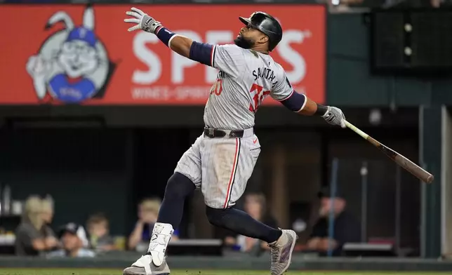 Minnesota Twins' Carlos Santana follows through on a sacrifice fly that scored Matt Wallner in the ninth inning of a baseball game against the Texas Rangers, Thursday, Aug. 15, 2024, in Arlington, Texas. (AP Photo/Tony Gutierrez)