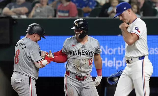 Minnesota Twins' Christian Vazquez (8) and Kyle Farmer (12) celebrate in front of Texas Rangers starting pitcher Cody Bradford, right, after Farmer hit a triple and then scored on a fielding error by center fielder Leody Taveras in the second inning of a baseball game, Thursday, Aug. 15, 2024, in Arlington, Texas. (AP Photo/Tony Gutierrez)