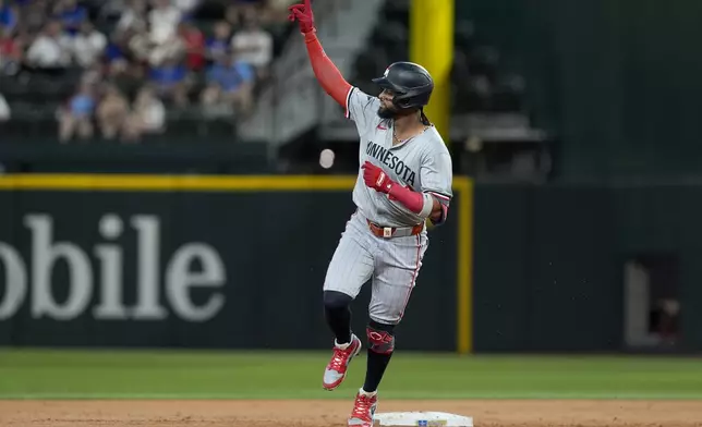 Minnesota Twins' Willi Castro celebrates his solo home run against the Texas Rangers as he rounds the bases in the second inning of a baseball game, Thursday, Aug. 15, 2024, in Arlington, Texas. (AP Photo/Tony Gutierrez)