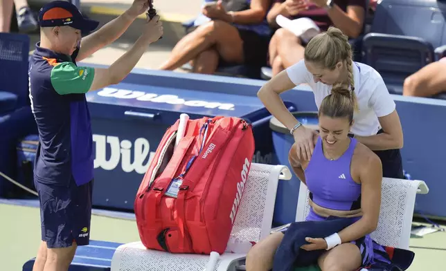 Maria Sakkari, of Greece, reacts as a trainer works on her shoulder between games against Wang Yafan, of China, during the first round of the U.S. Open tennis championships, Monday, Aug. 26, 2024, in New York. (AP Photo/Seth Wenig)