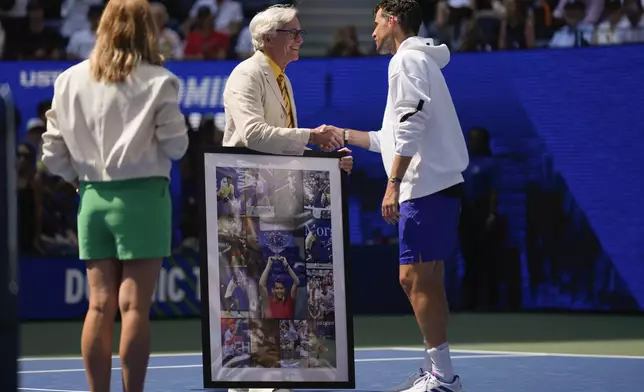 Dominic Thiem, of Austria, is presented with a collage of photos of his play at the U.S. Open over the years after losing to Ben Shelton, of the United States, during the first round of the U.S. Open tennis championships, Monday, Aug. 26, 2024, in New York. (AP Photo/Seth Wenig)