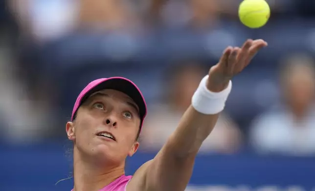 Iga Swiatek, of Poland, serves to Kamilla Rakhimova, during the first round of the U.S. Open tennis championships, Tuesday, Aug. 27, 2024, in New York. (AP Photo/Kirsty Wigglesworth)