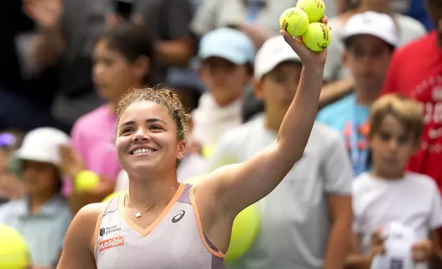 Jasmine Paolini, of Italy, prepares to hit autographed balls to fans after advancing to the next round when opponent Karolina Pliskova, of the Czech Republic, retired during the second round of the U.S. Open tennis championships, Thursday, Aug. 29, 2024, in New York. (AP Photo/Kirsty Wigglesworth)