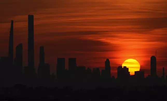 The sun sets behind the New York skyline during the first round of the U.S. Open tennis championships, Tuesday, Aug. 27, 2024, in New York. (AP Photo/Matt Rourke)