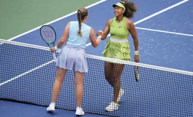 Naomi Osaka, of Japan, right, shakes hands with Jelena Ostapenko, of Latvia, after winning their first round match of the U.S. Open tennis championships, Tuesday, Aug. 27, 2024, in New York. (AP Photo/Seth Wenig)