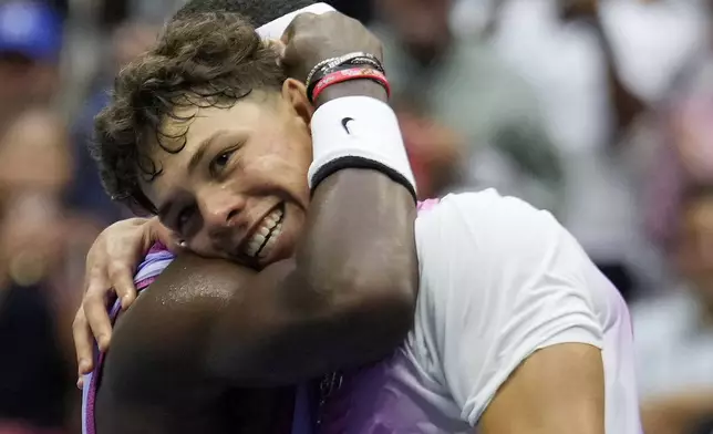 Frances Tiafoe, of the United States, left, hugs Ben Shelton, of the United States, at the net after winning their third round match of the U.S. Open tennis championships, Friday, Aug. 30, 2024, in New York. (AP Photo/Seth Wenig)