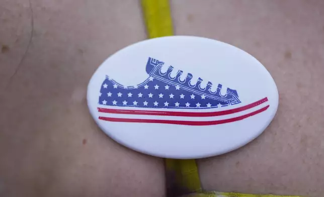 Illinois Rep. Kelly Cassidy wears a pin as she talks with visitors to the Glenwood Avenue Arts Festival about canvassing efforts for the Democratic Party, Monday, Aug. 26, 2024, in Chicago. (AP Photo/Erin Hooley)