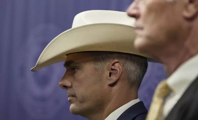 Ryan Christian, with the Texas Rangers, left, stands alongside First Assistant/Chief of Courts David Mitcham, right, as Harris County District Attorney Kim Ogg, not pictured, announces corruption charges related to 2022 Election during a press conference on Tuesday, Aug. 13, 2024, in Houston. (Raquel Natalicchio/Houston Chronicle via AP)