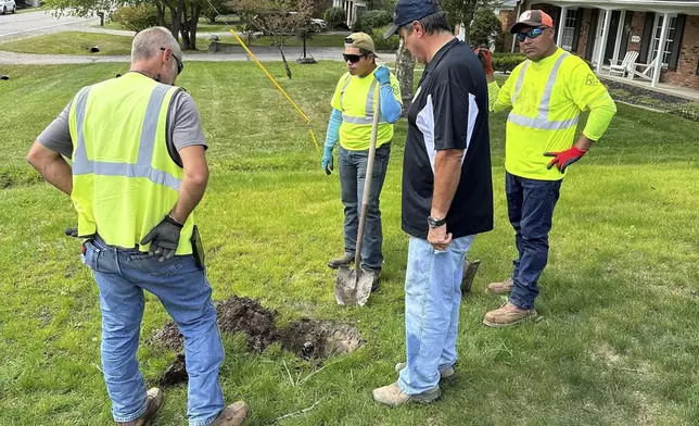 T &amp; J Landscaping owner Tom Caramagno, third from left, and members of his crew work Monday, Aug. 26, 2024, on a drainage issue outside a home in Bloomfield Township, northwest of Detroit, where the temperature was in the high 80s. (AP Photo/Corey Williams)