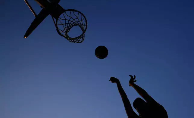 John Nguyen shoots hoops during a hot weather day in Deerfield, Ill., Monday, Aug. 26, 2024. (AP Photo/Nam Y. Huh)