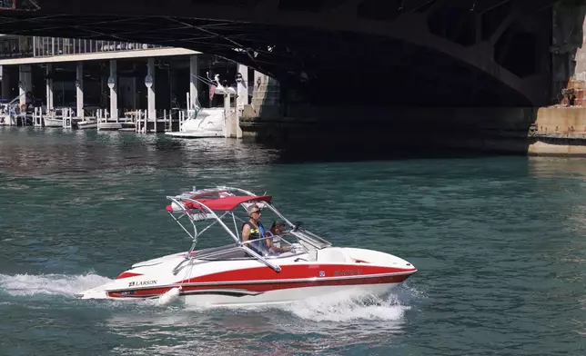 A boat rides along the riverwalk in the loop, Tuesday, Aug. 27, 2024, in Chicago. (Anthony Vazquez/Chicago Sun-Times via AP)