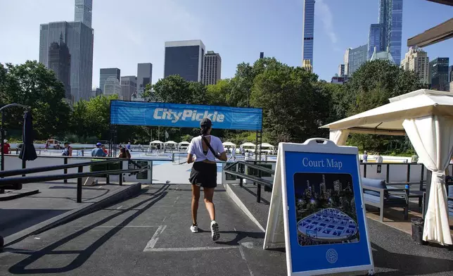 A woman arrives to the courts of CityPickle at Central Park's Wollman Rink, Saturday, Aug. 24, 2024, in New York. (AP Photo/Eduardo Munoz Alvarez)