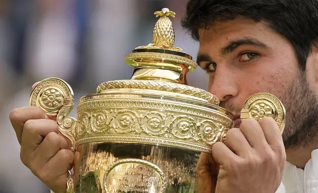 FILE - Spain's Carlos Alcaraz celebrates with the trophy after beating Serbia's Novak Djokovic to win the final of the men's singles at the Wimbledon tennis championships in London, Sunday, July 16, 2023. (AP Photo/Kirsty Wigglesworth, File)