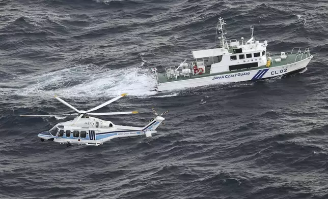 FILE - Japanese coast guard helicopter and patrol vessel conduct search and rescue operation in the waters where a U.S. military Osprey aircraft crashed into off the coast of Yakushima Island, Kagoshima prefecture, southern Japan, Nov. 30, 2023. (Kyodo News via AP, File)