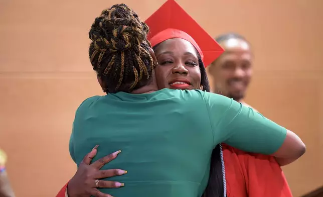 Sparkle Graham, right, is recognized for her achievement during a high school equivalency (HiSET) diploma graduation ceremony for the Youth Empowerment Project (YEP) in New Orleans, Thursday, June 27, 2024. (AP Photo/Matthew Hinton)