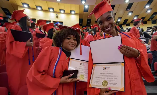 Keywanda Ashley, right, and Naomy Seiry Arzu Cruz show off their high school equivalency (HiSET) diplomas during a graduation ceremony for the Youth Empowerment Project (YEP), a New Orleans-based non-profit organization which received money from the NBA Foundation program in New Orleans, Thursday, June 27, 2024. (AP Photo/Matthew Hinton)