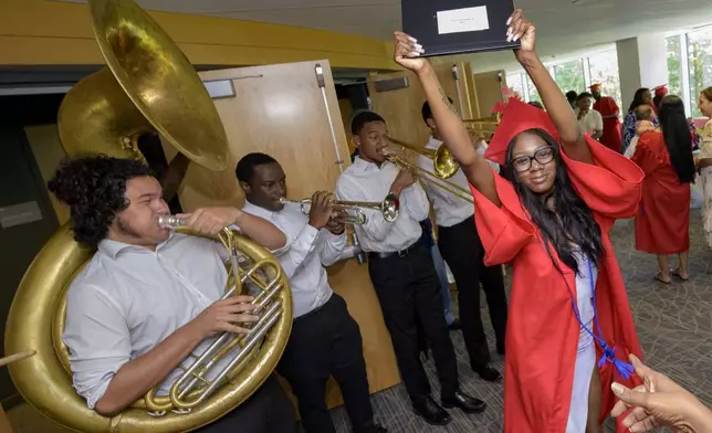 Skyy Stevenson dances to the music of the One Up Brass Band after receiving her high school equivalency (HiSET) diploma during a graduation ceremony for the Youth Empowerment Project (YEP) a non-profit organization in New Orleans, Thursday, June 27, 2024. (AP Photo/Matthew Hinton)