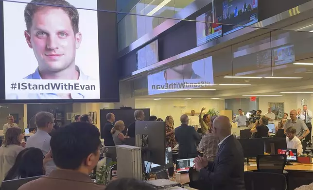 In this image taken from video, employees at the Wall Street Journal in New York applaud at the news that reporter Evan Gershkovich, pictured top left, has been released as part of a prisoner swap with Russia, the United States and several other countries, Thursday, Aug. 1, 2024. (Vaughn Sterling/The Wall Street Journal via AP)