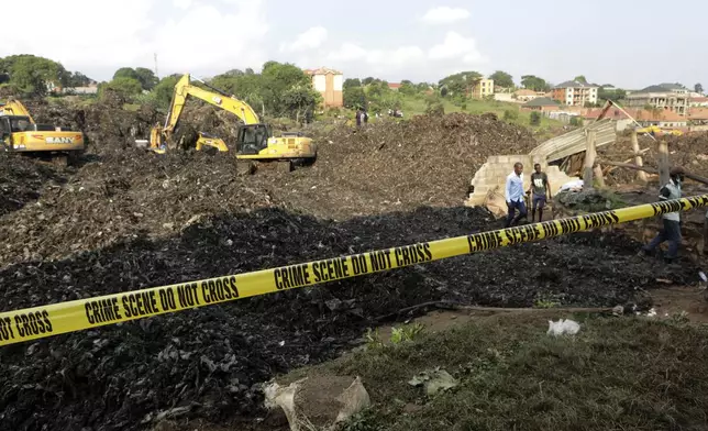 Onlookers watch as workers search for survivors at the site of a collapsed landfill in Kampala, Uganda, Sunday, Aug. 11, 2024. (AP Photo/Hajarah Nalwadda)