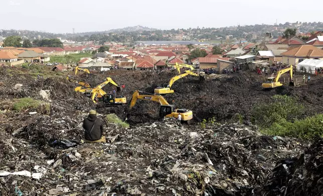 Onlookers watch as workers search for survivors at the site of a collapsed landfill in Kampala, Uganda, Sunday, Aug. 11, 2024. (AP Photo/Hajarah Nalwadda)