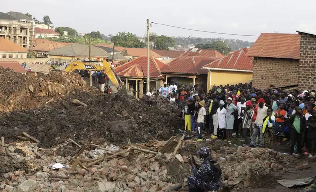 Onlookers watch as workers search for survivors at the site of a collapsed landfill in Kampala, Uganda, Sunday, Aug. 11, 2024. (AP Photo/Hajarah Nalwadda)