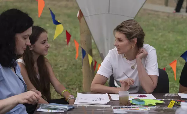 First lady Olena Zelenska talks to a girl during her visit to the rehabilitation camp "Loud Camp" for children affected by war, organized by the Voices of Children Charitable Foundation and financially supported by the Olena Zelenska Foundation in Uzhhorod, Ukraine, Tuesday, Aug. 27, 2024. (AP Photo/Efrem Lukatsky)