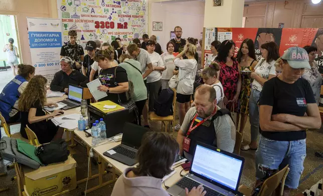 People line up to register for evacuation in Pokrovsk, Donetsk region, Ukraine, Friday, Aug. 23, 2024. (AP Photo/Evgeniy Maloletka)