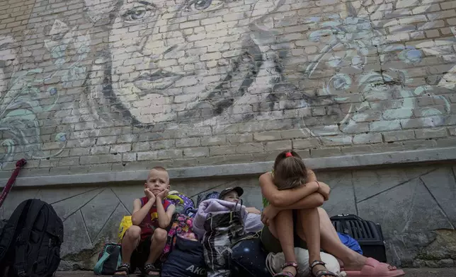 People wait for evacuation in Pokrovsk, Donetsk region, Ukraine, Friday, Aug. 23, 2024. (AP Photo/Evgeniy Maloletka)