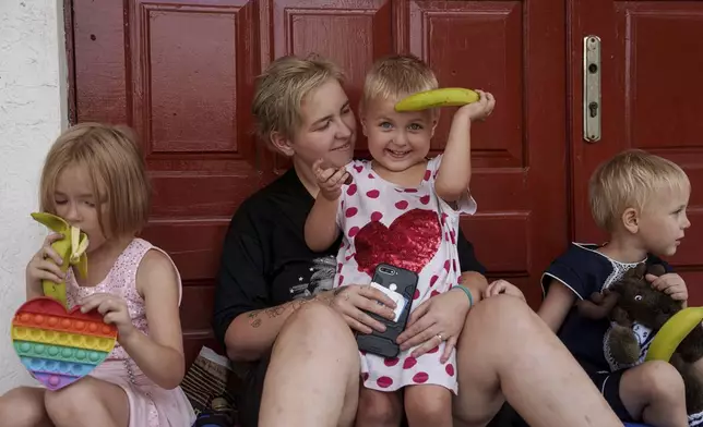 Nadia Trushenko, with her daughters Ksenia, left, Daria, center and Liubov, wait for evacuation in Pokrovsk, Donetsk region, Ukraine, Friday, Aug. 23, 2024. (AP Photo/Evgeniy Maloletka)