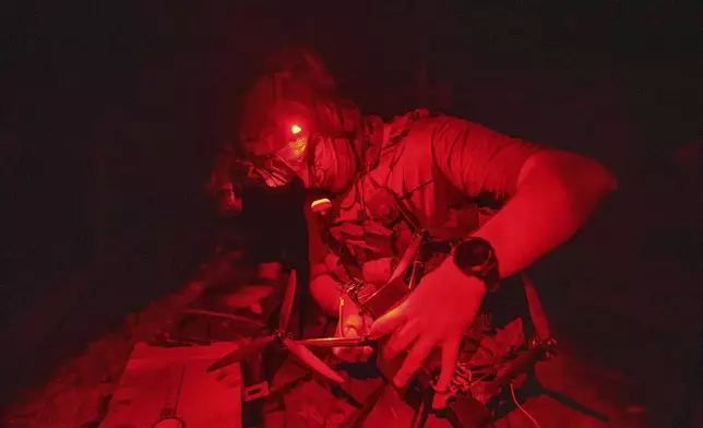 A Ukrainian soldier of 3rd assault brigade prepares FPV exploding drone before flight over Russian positions in Kharkiv region, Ukraine, on Sunday, Aug. 25, 2024. (AP Photo/Evgeniy Maloletka)