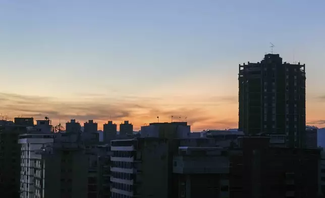 Buildings stand in darkness during a power outage in Caracas, Venezuela, at dawn on Friday, Aug. 30, 2024. (AP Photo/Ariana Cubillos)